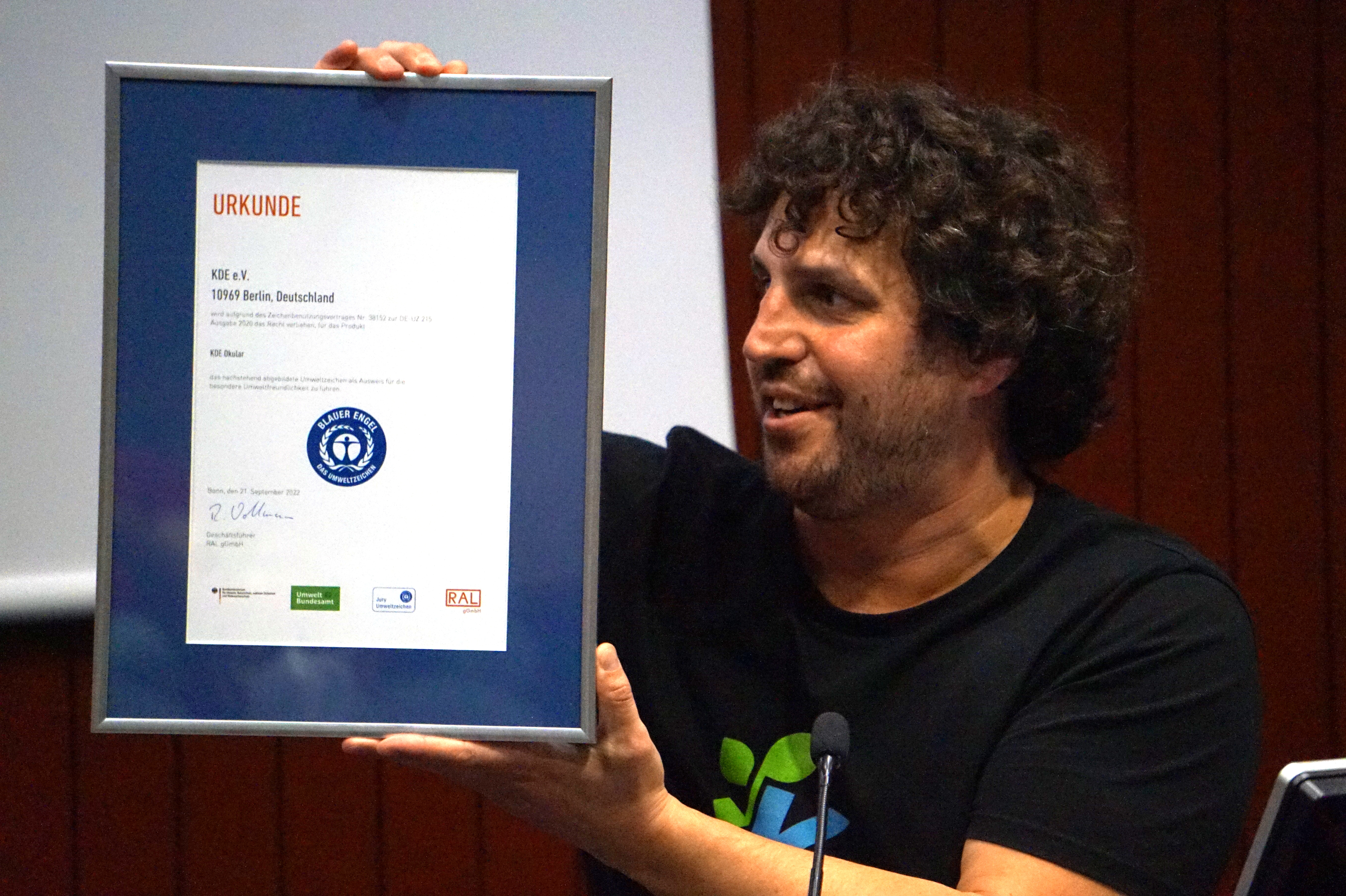 Joseph De Veaugh-Geiss shows the eco-certification awarded to KDE's Okular PDF-document reader.