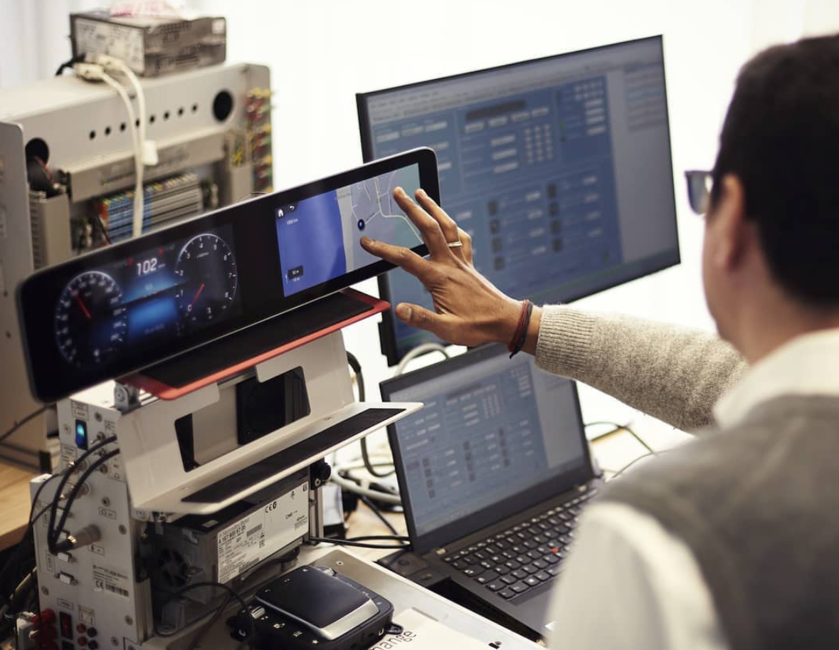 Engineers working on a car user interface with a lot of high tech gadgets and computers